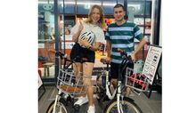 A couple poses with a compact electric folding bike at Shiibuya-san bike tour