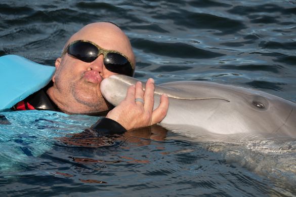U.S. Navy Petty Officer First Class Jerry Wayne Padgett II enjoys a smooch with a dolphin at Dolphin Research Center Sunday, Jan. 11, 2026, in Marathon, Fla. Padgett was among more than 40 wounded military personnel who participated in Soldier Ride, a Sou