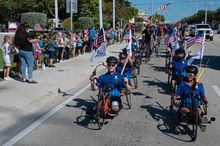 Wounded veterans and their supporters ride adaptive and regular bicycles past elementary school students and their teachers on the Florida Keys Overseas Highway Friday, Jan. 9, 2026, in Marathon, Fla. Organized by the Wounded Warrior Project, the Soldier 
